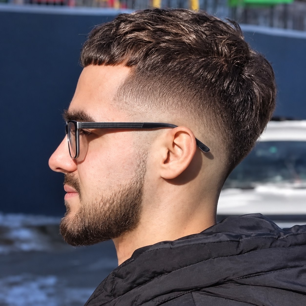 Coupe courte texturée avec dégradé et barbe dessinée, vue de profil
